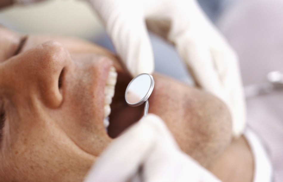 Man getting his teeth inspected at the dentist.